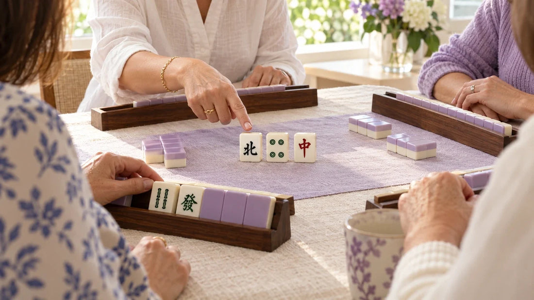 A teacher pointing to sample mahjong tiles while learners sit around a lilac playing mat.