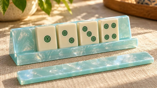 A pale blue acrylic mahjong rack holding four Dot tiles, with its separate pusher in front.