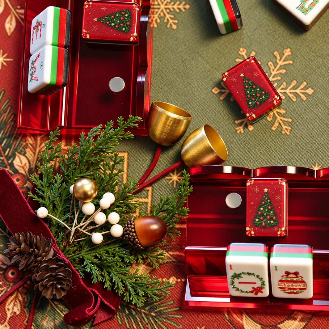 Ruby red acrylic mahjong racks styled with Christmas mahjong tiles, evergreen branches, gold bells and a burgundy ribbon.